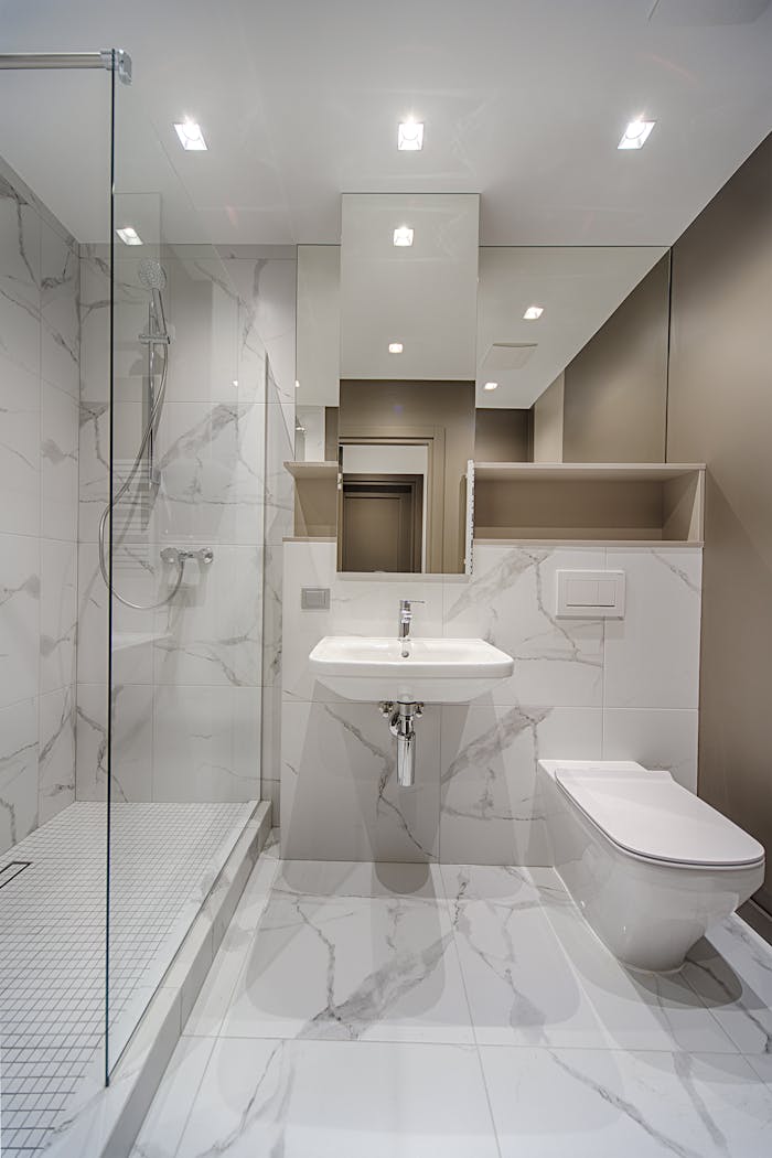 Minimalist bathroom with marble tiles, modern fixtures, and spacious design.